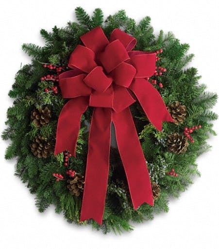 Fir wreath with juniper branches, pine cones, berries and red ribbon.