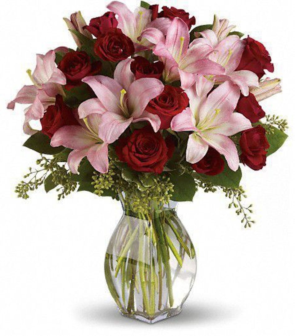 Red roses & pink lilies in a clear glass vase.